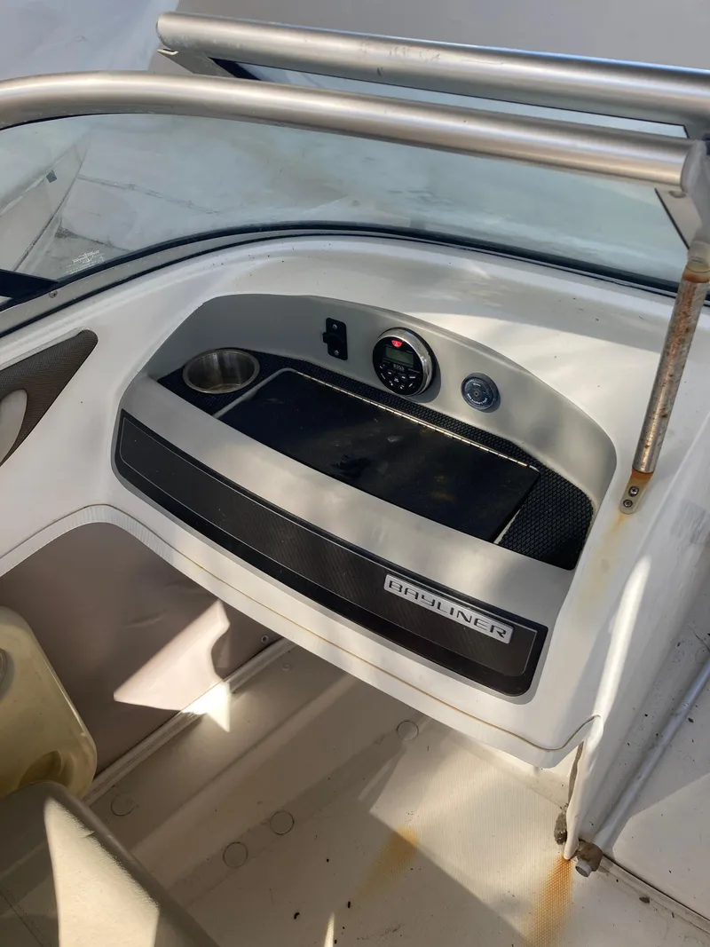 Slide: The Image of 2014 Bayliner 180 Bowrider dashboard with cup holder and controls. - 9