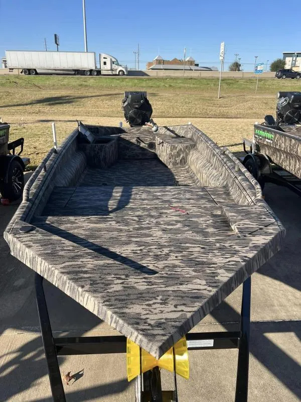Slide: The Image of 2024 Havoc Boats 1756MSTC camo-patterned boat on trailer, outdoor display. - 3