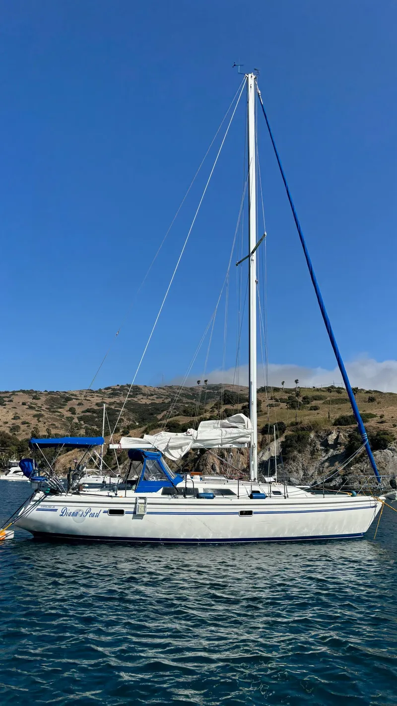 Slide: The Image of 1994 Catalina 36 sailboat anchored in scenic coastal waters. - 1