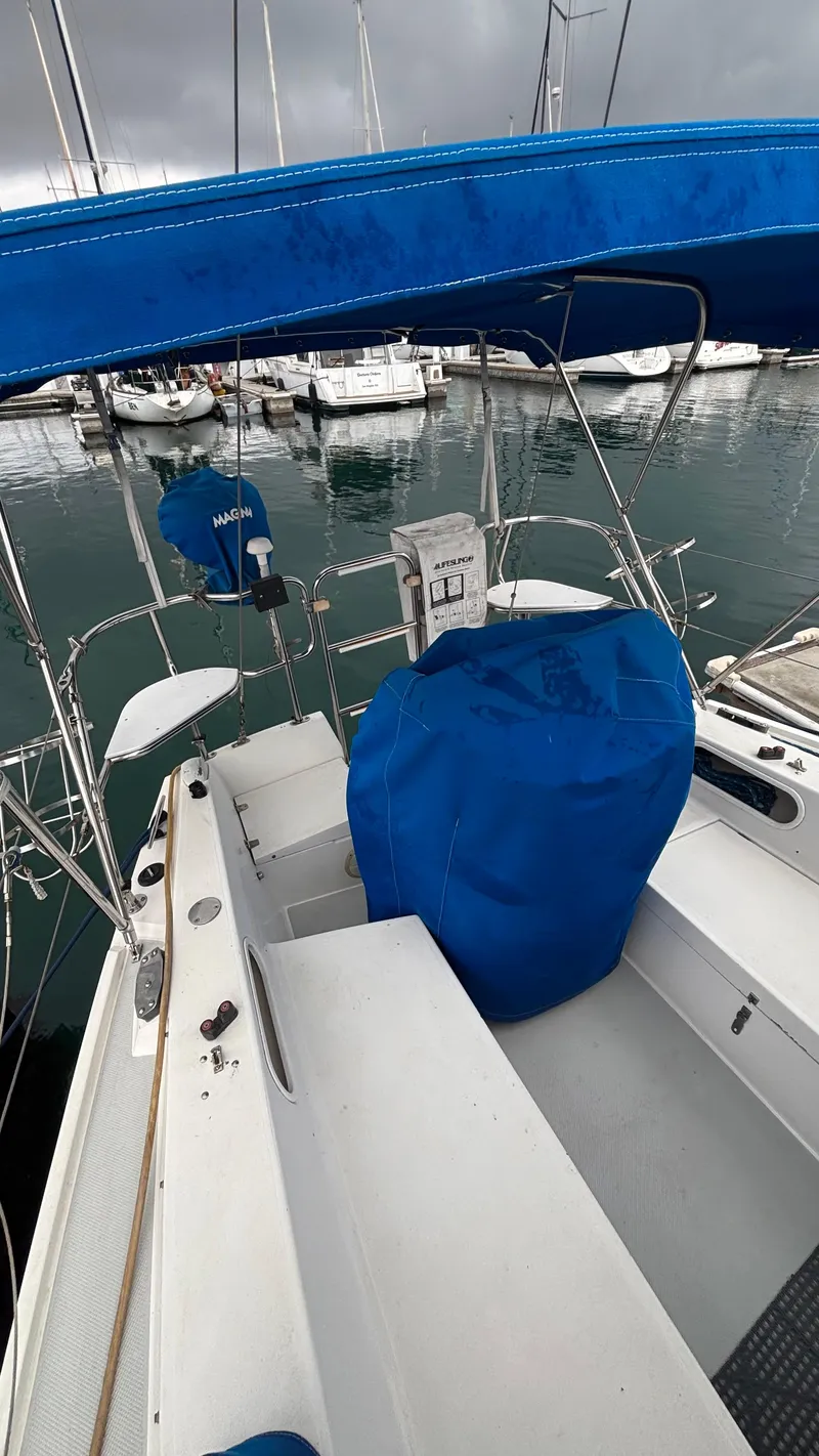 Slide: The Image of 1994 Catalina 36 sailboat with blue covers docked at a marina. - 11