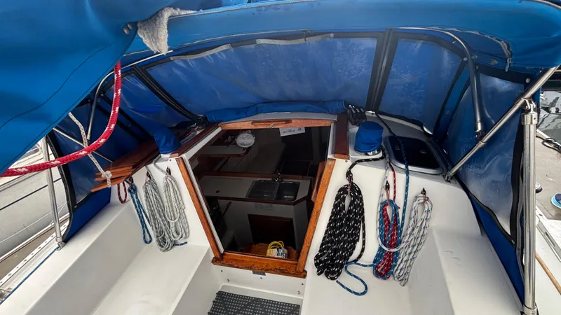 Slide: The Image of 1994 Catalina 36 sailboat cockpit with blue canopy and neatly coiled ropes. - 14