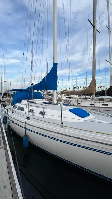 Slide: The Image of 1994 Catalina 36 sailboat docked at marina under cloudy sky. - 2