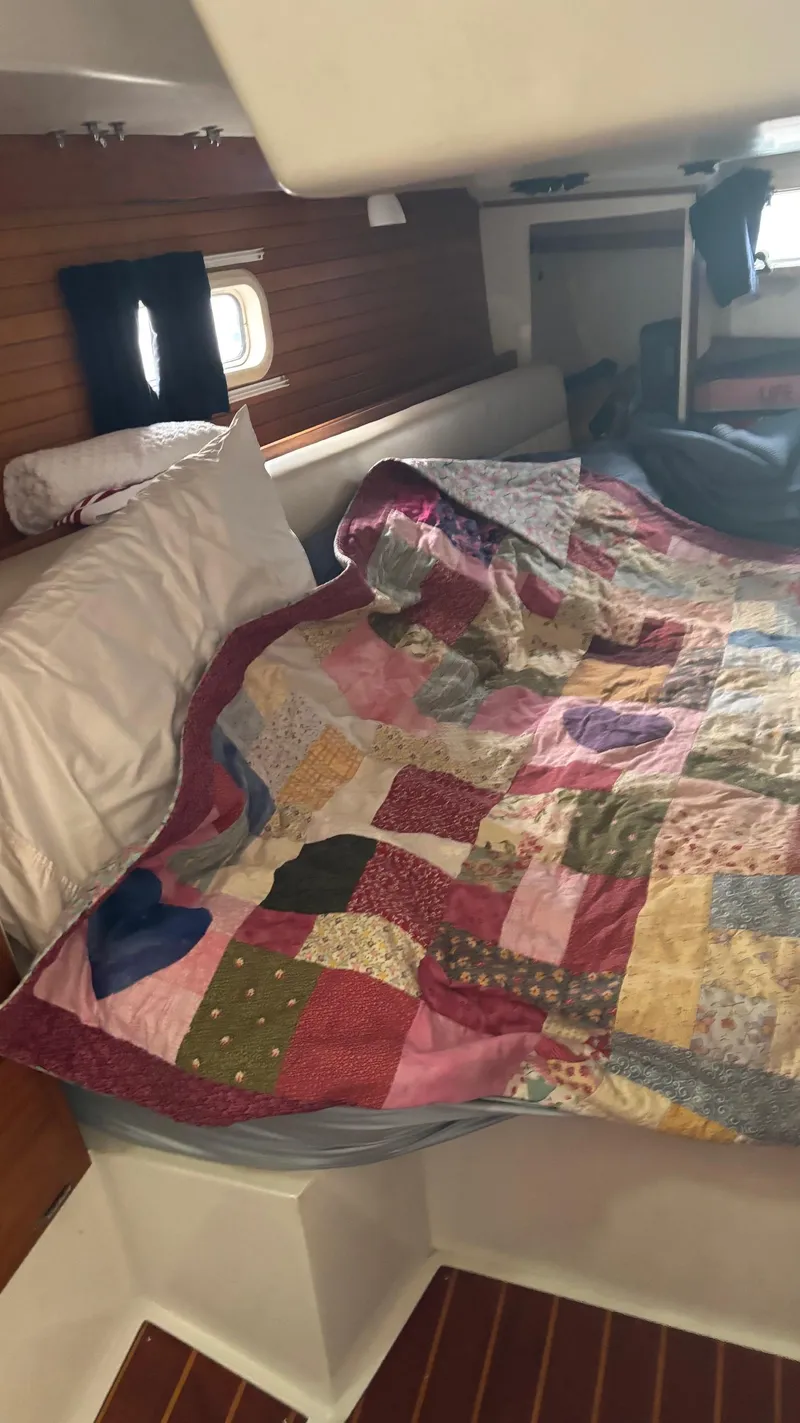 Slide: The Image of Cozy cabin interior of a 1994 Catalina 36 sailboat with a colorful patchwork quilt. - 24