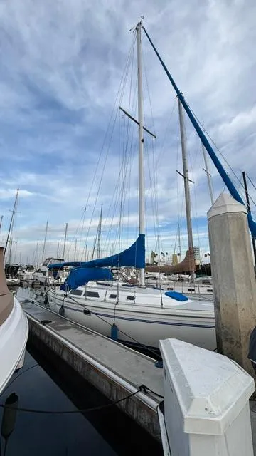 Slide: The Image of 1994 Catalina 36 sailboat docked at marina under cloudy sky. - 3