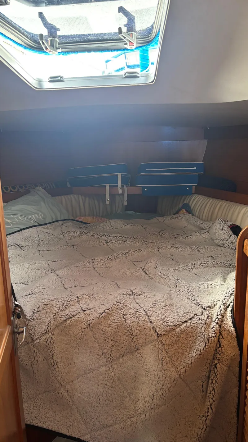 Slide: The Image of Cozy cabin interior of a 1994 Catalina 36 sailboat with a comfortable bed and overhead hatch. - 32