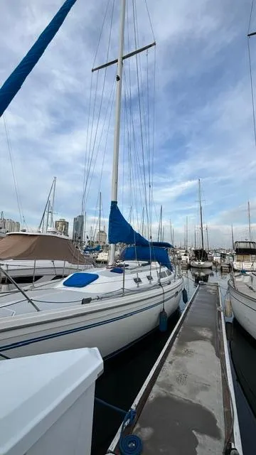Slide: The Image of 1994 Catalina 36 sailboat docked at marina under cloudy sky. - 6