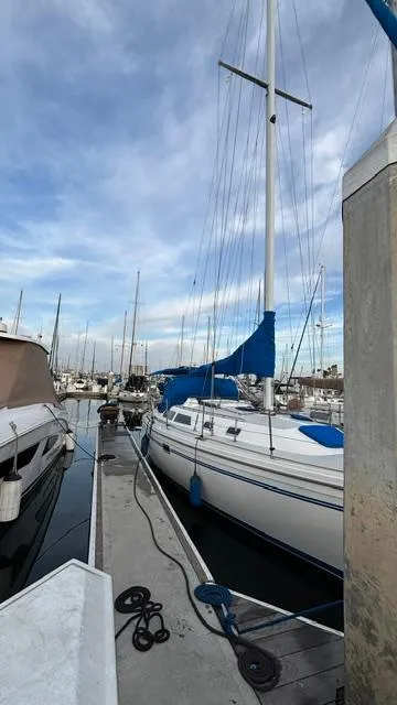 Slide: The Image of 1994 Catalina 36 sailboat docked at marina under cloudy sky. - 7