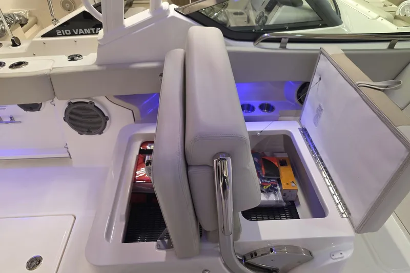 Slide: The Image of 2025 Boston Whaler 240 Vantage boat interior with storage compartment open, showcasing seating and speakers. - 20