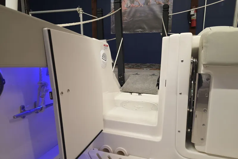 Slide: The Image of 2025 Boston Whaler 240 Vantage interior with open storage compartment and blue lighting. - 21