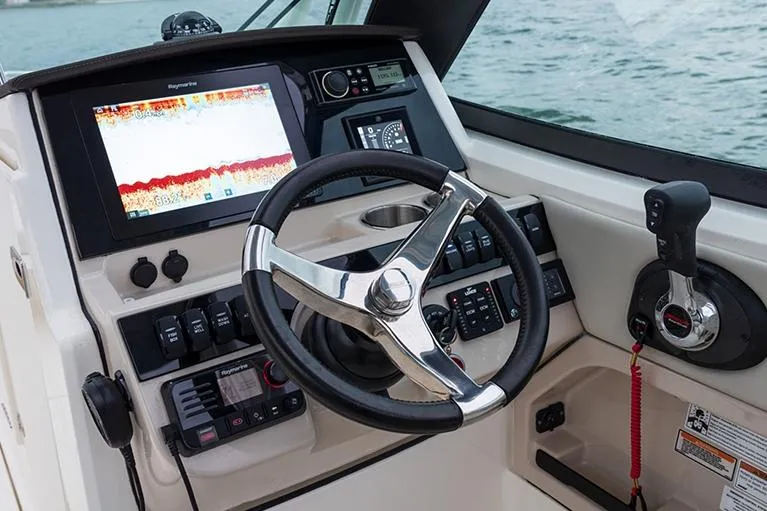 Slide: The Image of Control panel inside 2025 Boston Whaler 240 Vantage boat with blue lighting. - 13