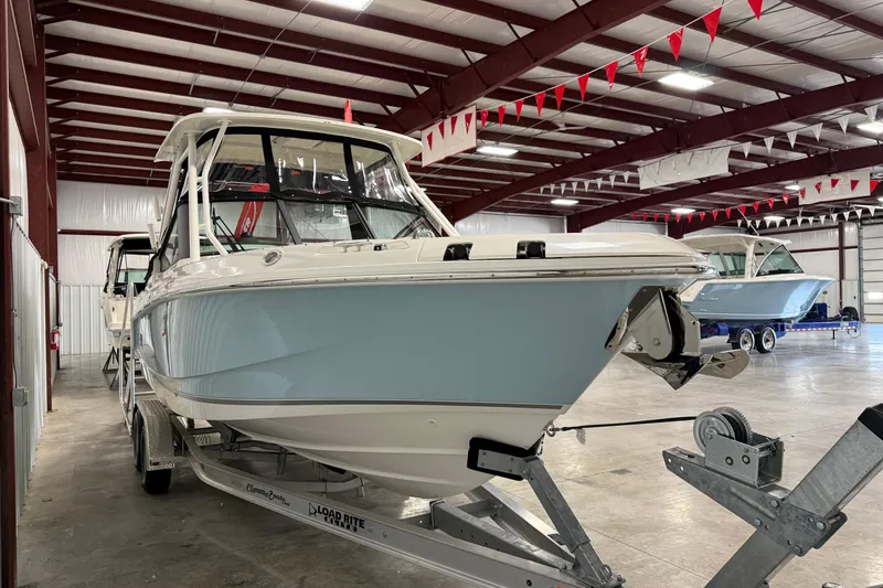Slide: The Image of 2025 Boston Whaler 240 Vantage boat in indoor showroom on trailer. - 2