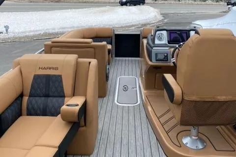 Slide: The Image of 2022 Harris Solstice 230 boat interior with tan leather seating and modern dashboard. - 18