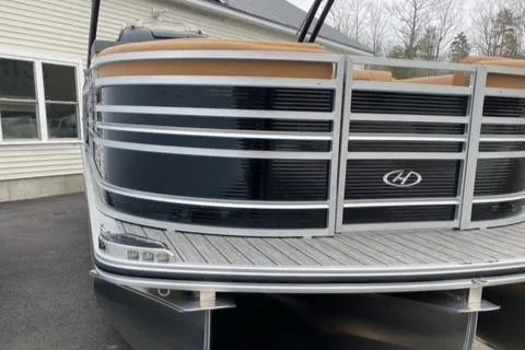 Slide: The Image of 2022 Harris Solstice 230 pontoon boat, front view, parked near a building. - 4