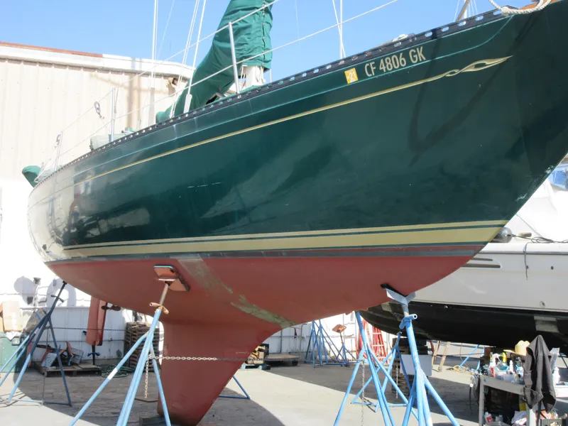 Slide: The Image of 1978 Islander sailboat with green hull on stands in a boatyard. - 4