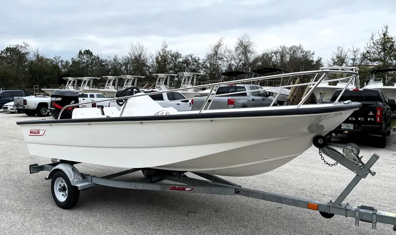 Slide: The Image of 2003 Boston Whaler 150 Sport boat on trailer in parking lot. - 1