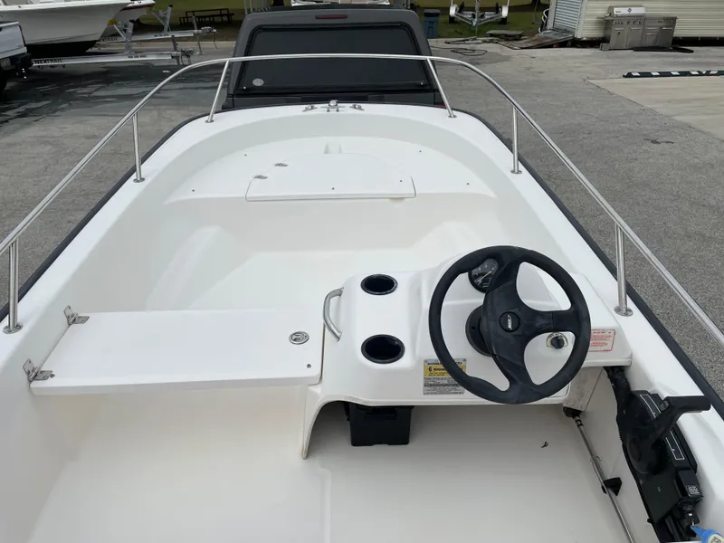 Slide: The Image of 2003 Boston Whaler 150 Sport boat interior with steering wheel and seating area. - 10