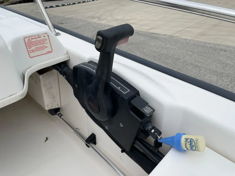 Slide: The Image of Throttle control of a 2003 Boston Whaler 150 Sport boat, featuring a safety lanyard. - 11