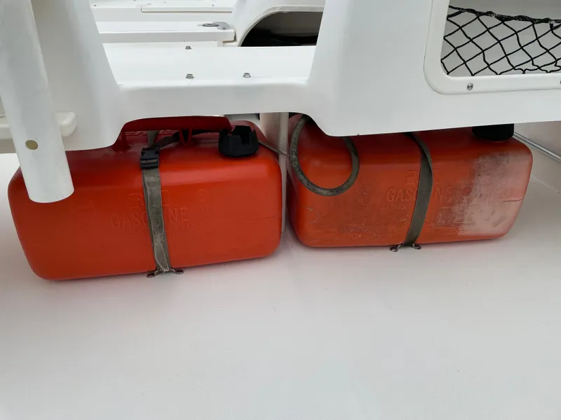 Slide: The Image of Two orange fuel tanks secured on a 2003 Boston Whaler 150 Sport boat. - 14