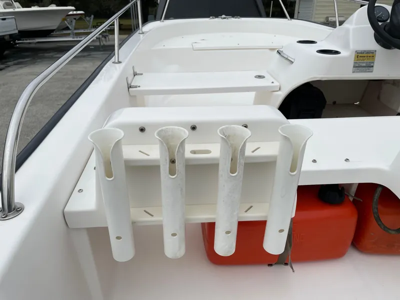 Slide: The Image of 2003 Boston Whaler 150 Sport boat interior with rod holders and storage compartments. - 15