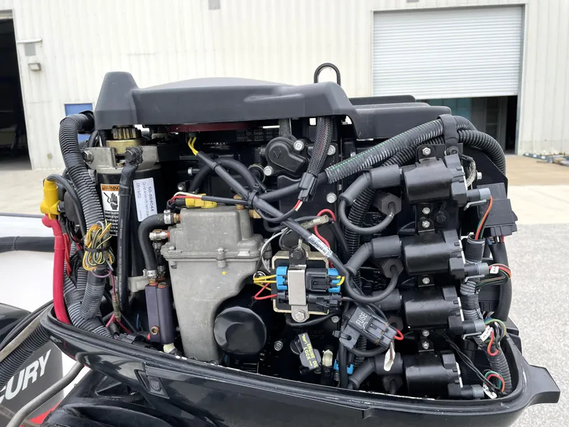 Slide: The Image of Close-up of a 2003 Boston Whaler 150 Sport boat engine, showcasing intricate wiring and components. - 19