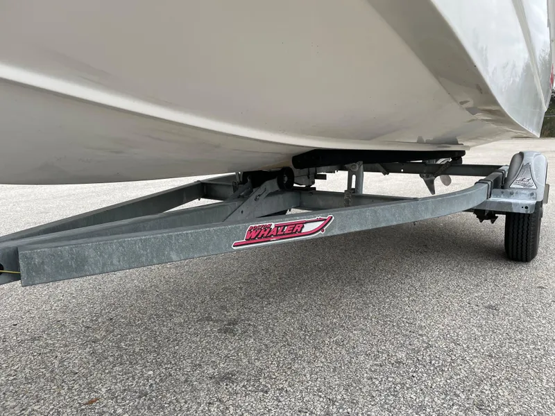 Slide: The Image of 2003 Boston Whaler 150 Sport boat on a trailer, close-up view. - 21