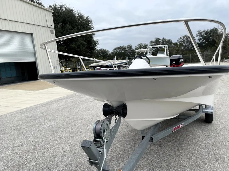 Slide: The Image of 2003 Boston Whaler 150 Sport boat on trailer near warehouse. - 7