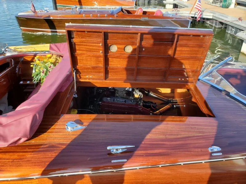 Slide: The Image of Classic 2021 Wilson Watercar with open engine compartment, wooden finish, docked by the water. - 14