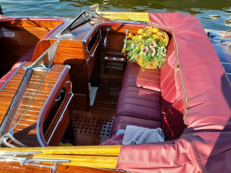 Slide: The Image of Luxurious 2021 Classic Wilson Watercar interior with burgundy seats and floral arrangement. - 17