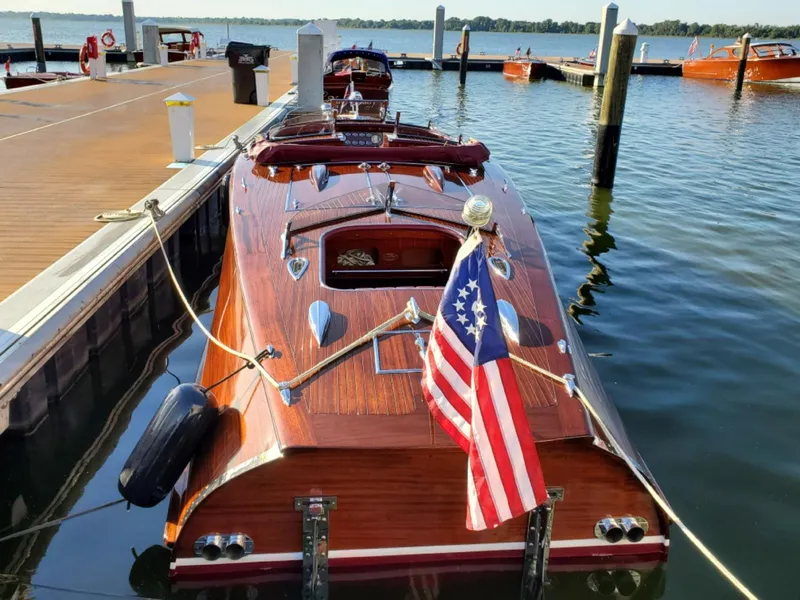 Slide: The Image of Classic 2021 Wilson Watercar docked, featuring wooden design and American flag. - 18