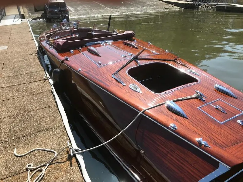 Slide: The Image of Classic 2021 Wilson Watercar with wooden finish docked by the water. - 4