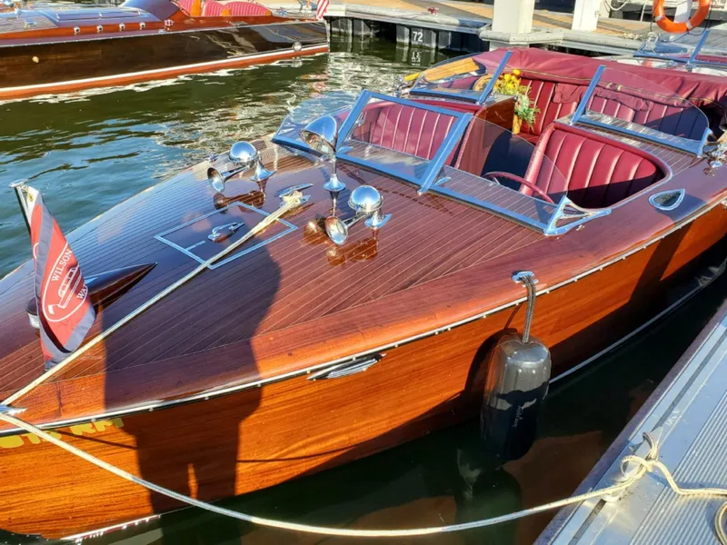Slide: The Image of Classic 2021 Wilson Watercar with wooden finish and red interior, docked at marina. - 6