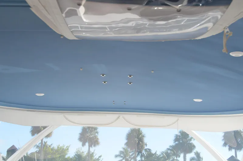 Slide: The Image of Ceiling view of 2022 Intrepid 438 Evolution boat with blue interior and palm trees outside. - 15