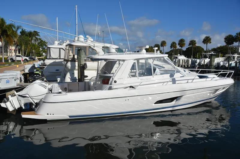 Slide: The Image of 2022 Intrepid 438 Evolution yacht docked in a marina under a clear blue sky. - 3