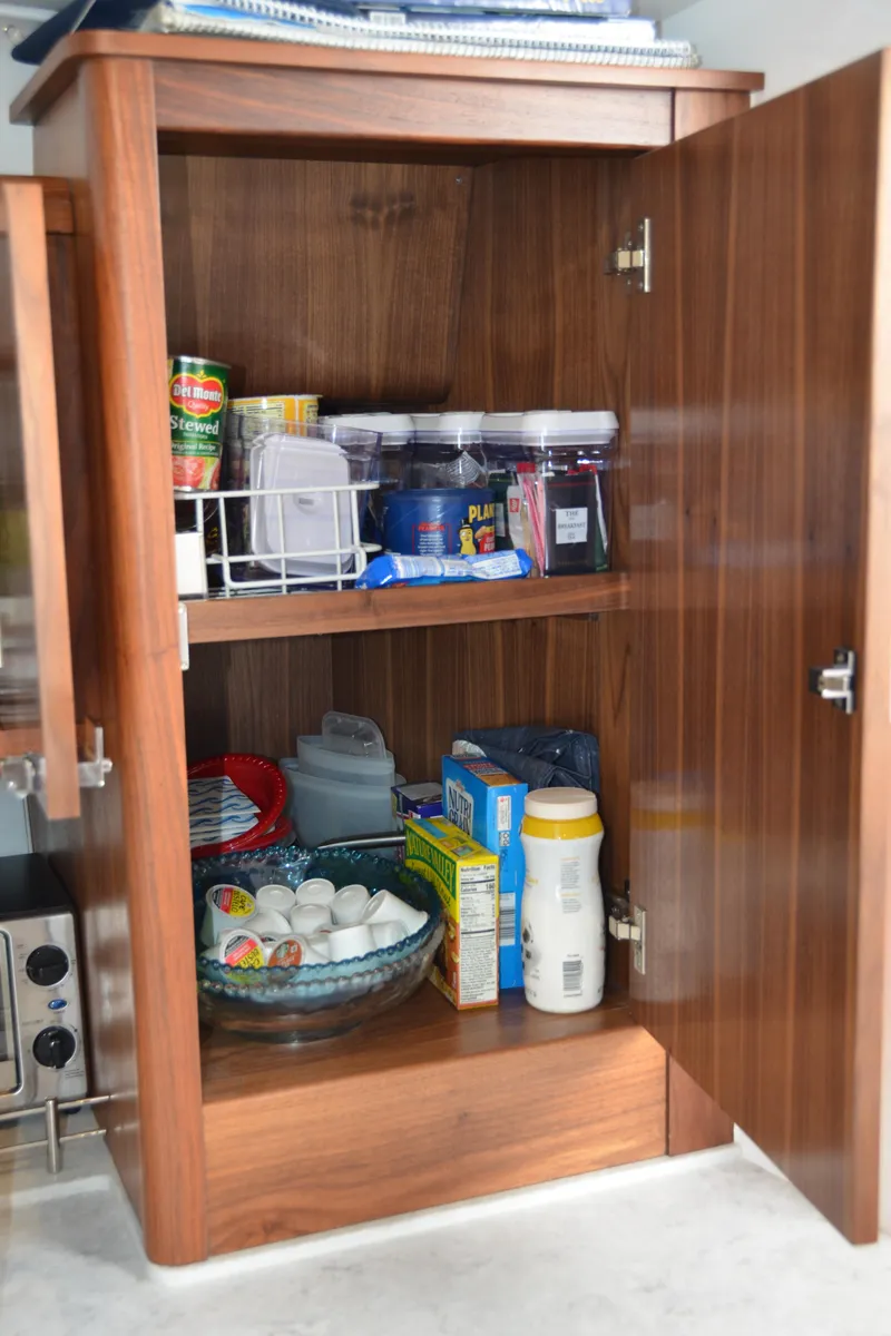 Slide: The Image of Wooden cabinet with assorted pantry items on a 2022 Intrepid 438 Evolution boat. - 36