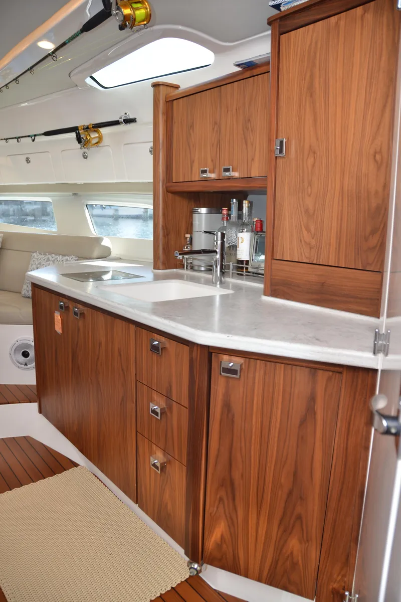 Slide: The Image of 2022 Intrepid 438 Evolution yacht interior with elegant wooden cabinetry and modern kitchen amenities. - 37