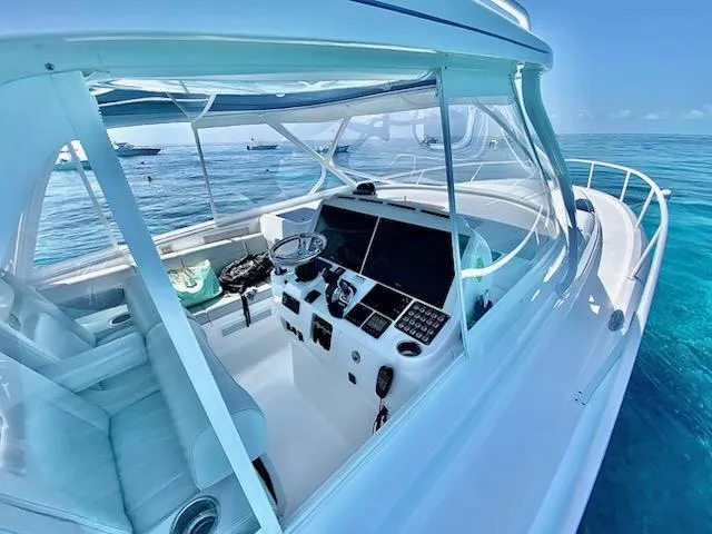 Slide: The Image of 2022 Intrepid 438 Evolution yacht cockpit with modern controls, cruising on clear blue waters. - 5