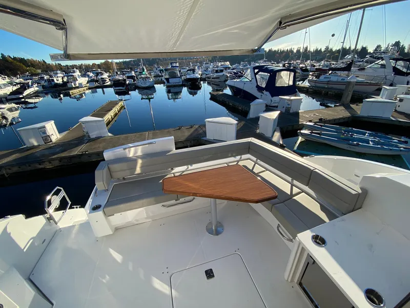 Slide: The Image of 2025 Cruisers Yachts 46 Cantius, spacious deck with seating, docked at marina. - 19