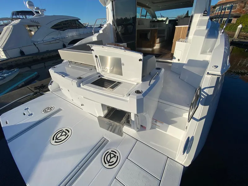 Slide: The Image of 2025 Cruisers Yachts 46 Cantius, luxury yacht deck with outdoor kitchen and seating area. - 17