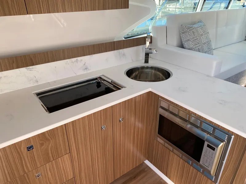 Slide: The Image of Modern kitchen in 2025 Cruisers Yachts 46 Cantius with wood cabinetry and stainless steel appliances. - 26