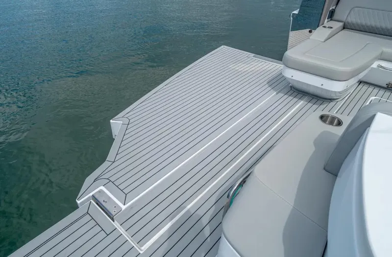 Slide: The Image of 2025 Cruisers Yachts 50 GLS swim platform and seating area on calm water. - 13
