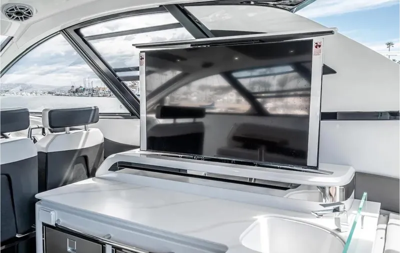 Slide: The Image of Luxurious interior of 2025 Cruisers Yachts 50 GLS with modern TV and seating. - 24