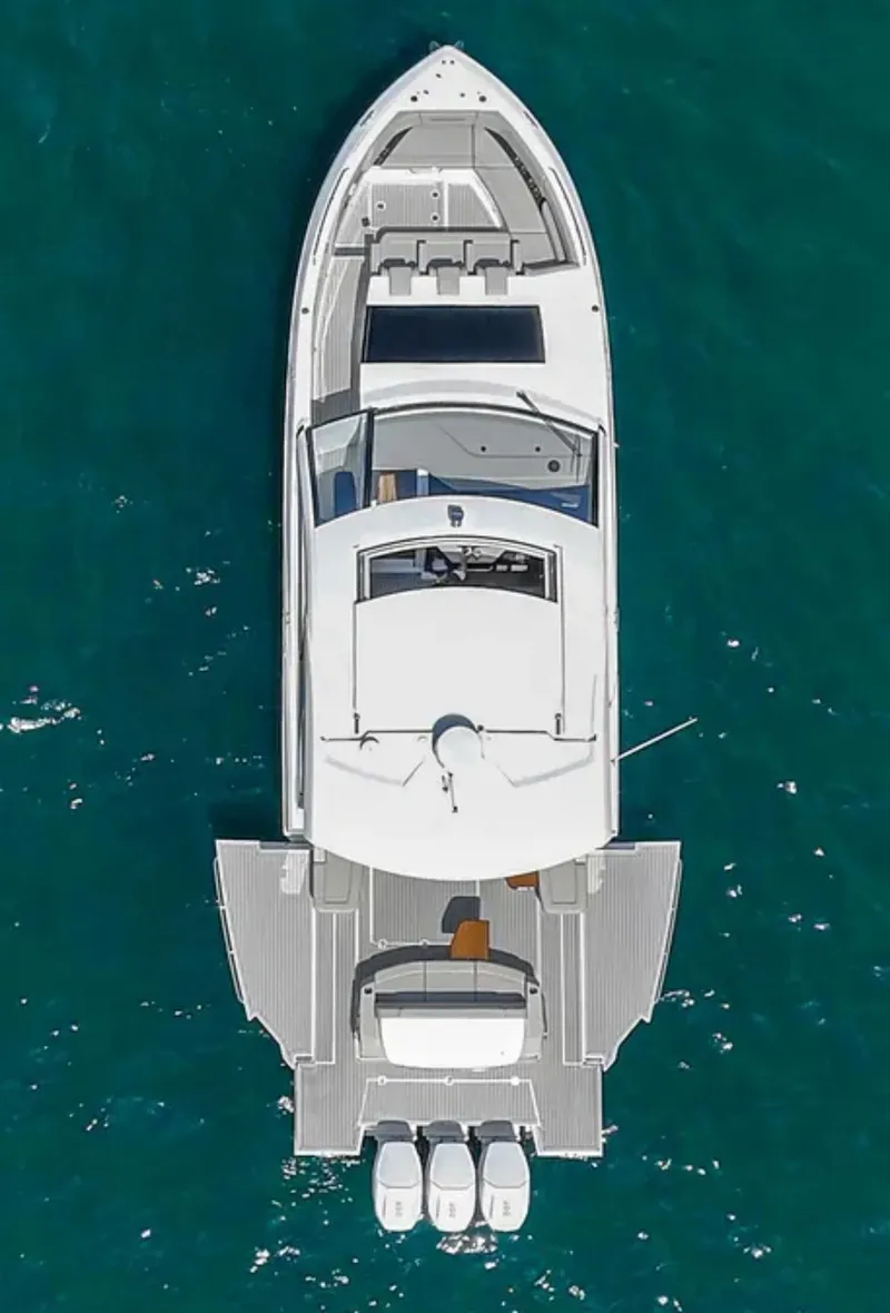 Slide: The Image of 2025 Cruisers Yachts 50 GLS, aerial view, sleek design on blue water. - 7