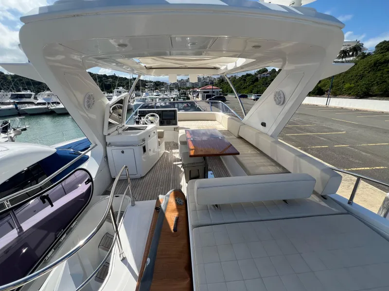 Slide: The Image of 2016 Azimut 54fly yacht with spacious deck and seating area in marina setting. - 10