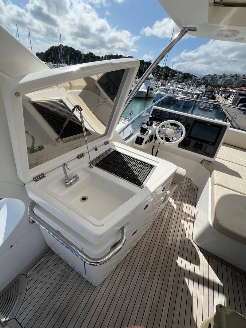 Slide: The Image of 2016 Azimut 54fly yacht with outdoor sink and helm, docked at marina. - 11