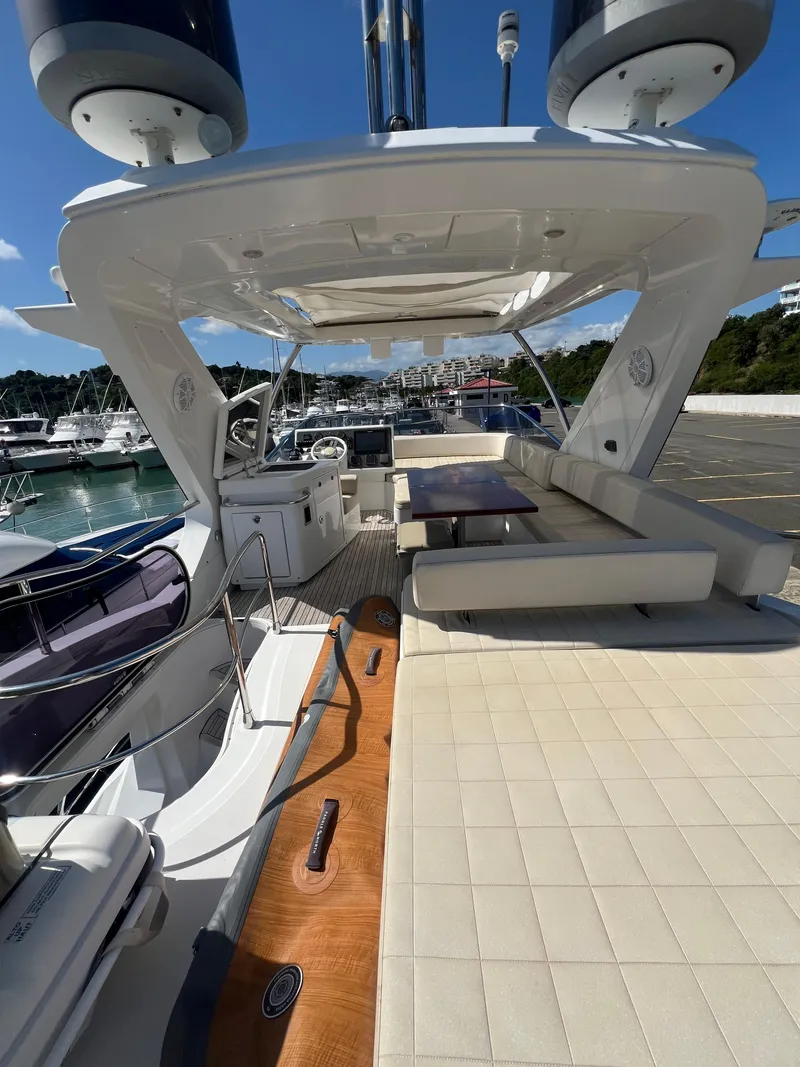 Slide: The Image of Azimut 54fly 2016 yacht with spacious deck, seating, and table, docked at marina. - 16