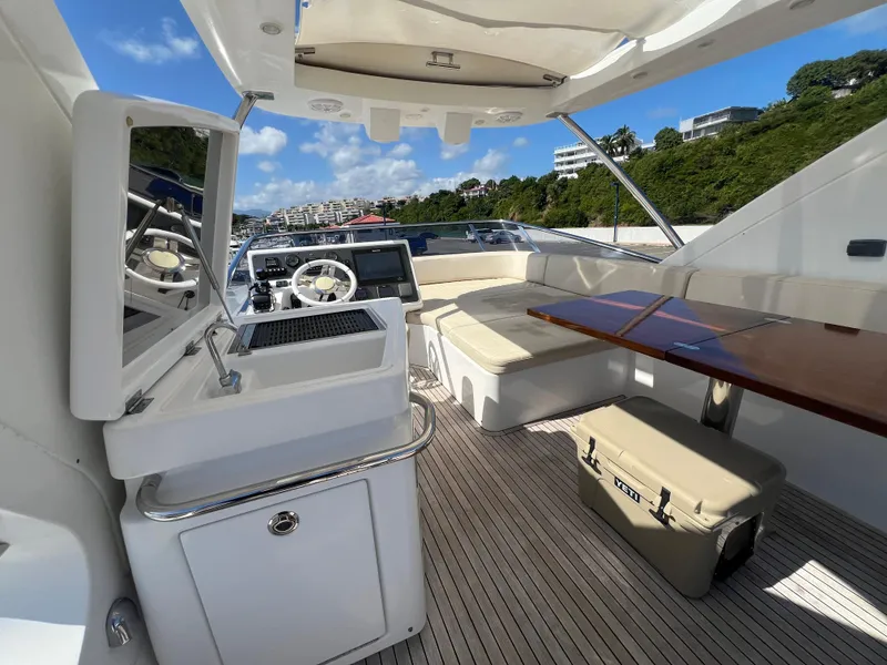 Slide: The Image of Luxurious 2016 Azimut 54fly yacht interior with seating, table, and helm under a sunny sky. - 17