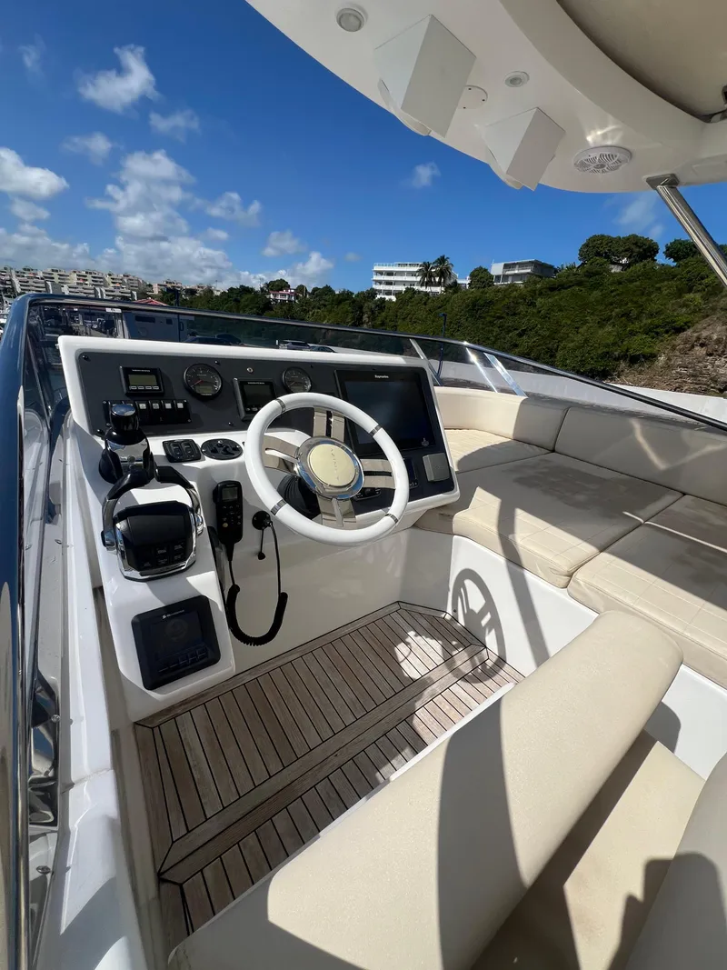 Slide: The Image of 2016 Azimut 54fly yacht helm with modern controls and beige seating under blue sky. - 22