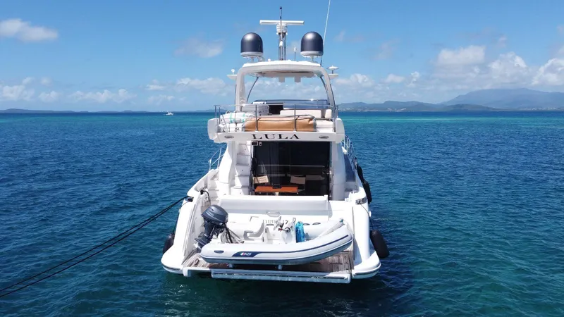 Slide: The Image of 2016 Azimut 54fly yacht anchored in clear blue ocean waters. - 3
