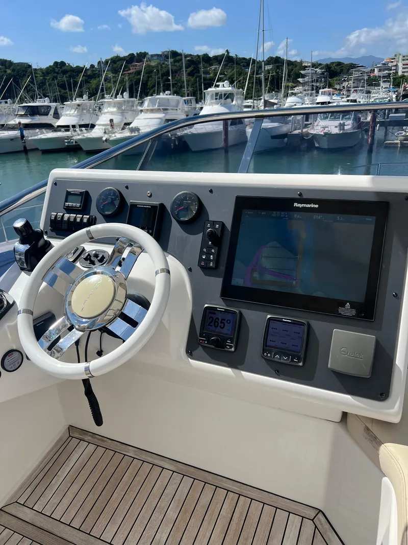 Slide: The Image of 2016 Azimut 54fly yacht helm with modern navigation controls and scenic marina backdrop. - 31