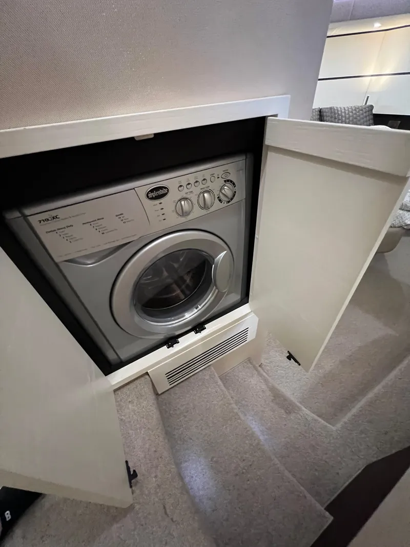 Slide: The Image of Washing machine inside 2016 Azimut 54fly yacht, with open cabinet doors. - 46